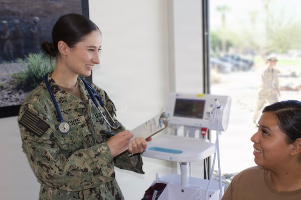 Hospitalman Chloe Gerimonte (left) provides care to a patient at the Adult Medical Care Clinic at Navy Medicine Readiness and Training Command Twentynine Palms aboard Marine Corps Air Ground Combat Center Twentynine Palms, California, April 1, 2026. Gerimonte previously worked at the clinic as a civilian contractor before joining the Navy Hospital Corps. (U.S. Navy photo by Hospital Apprentice Evelyn Zermeno, NH/NMRTC Twentynine Palms public affairs).