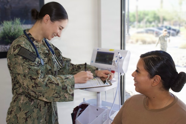 Hospitalman Chloe Gerimonte (left) provides care to a patient at the Adult Medical Care Clinic at Navy Medicine Readiness and Training Command Twentynine Palms aboard Marine Corps Air Ground Combat Center Twentynine Palms, California, April 1, 2026. Gerimonte previously worked at the clinic as a civilian contractor before joining the Navy Hospital Corps. (U.S. Navy photo by Hospital Apprentice Evelyn Zermeno, NH/NMRTC Twentynine Palms public affairs).