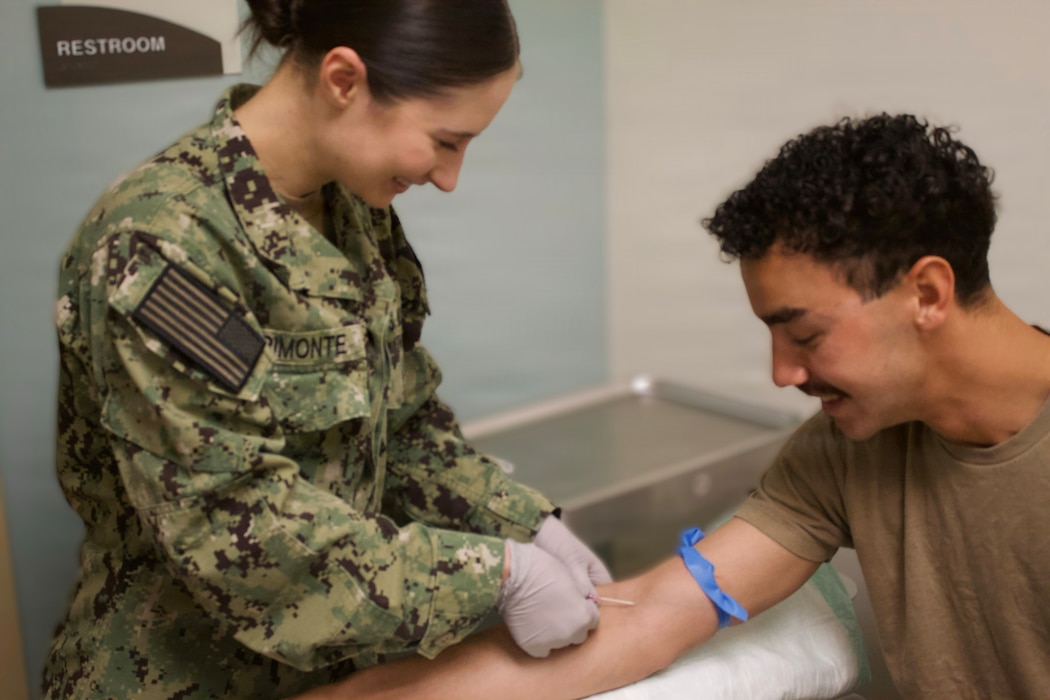 Hospitalman Chloe Gerimonte (left) provides care to Hospital Corpsman 3rd Class Ayden Massey at the Adult Medical Care Clinic at Navy Medicine Readiness and Training Command Twentynine Palms aboard Marine Corps Air Ground Combat Center Twentynine Palms, California, April 1, 2026. Gerimonte serves as a Hospital Corpsman at the clinic, supporting patient care and medical readiness for Sailors and Marines. (U.S. Navy photo by Hospital Apprentice Evelyn Zermeno, NH/NMRTC Twentynine Palms public affairs).