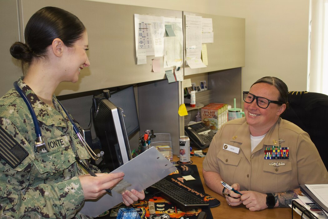 Hospitalman Chloe Gerimonte (left) meets with Chief Hospital Corpsman Kayla Siem at the Adult Medical Care Clinic at Navy Medicine Readiness and Training Command Twentynine Palms aboard Marine Corps Air Ground Combat Center Twentynine Palms, California, April 1, 2026. Gerimonte serves as a Hospital Corpsman at the clinic, where she supports patient care and medical readiness for Sailors and Marines. (U.S. Navy photo by Hospital Apprentice Evelyn Zermeno, NH/NMRTC Twentynine Palms public affairs).