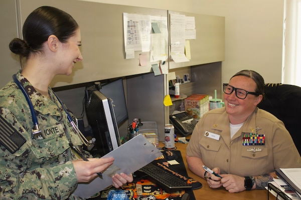 Hospitalman Chloe Gerimonte (left) meets with Chief Hospital Corpsman Kayla Siem at the Adult Medical Care Clinic at Navy Medicine Readiness and Training Command Twentynine Palms aboard Marine Corps Air Ground Combat Center Twentynine Palms, California, April 1, 2026. Gerimonte serves as a Hospital Corpsman at the clinic, where she supports patient care and medical readiness for Sailors and Marines. (U.S. Navy photo by Hospital Apprentice Evelyn Zermeno, NH/NMRTC Twentynine Palms public affairs).