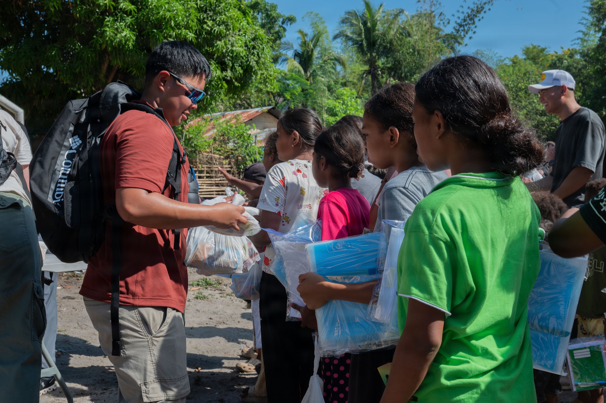 U.S. Air Force Senior Airman Geon Donato, 21st Combat Air Base Squadron structural journeyman, hands out snacks during a humanitarian outreach event at Haduan Village, Philippines, May 20, 2026. The event highlighted the 21st Air Expeditionary Wing’s commitment to community involvement, strengthening ties with local organizations and residents. (U.S. Air Force photo by Senior Airman Alondra Cristobal Hernandez)