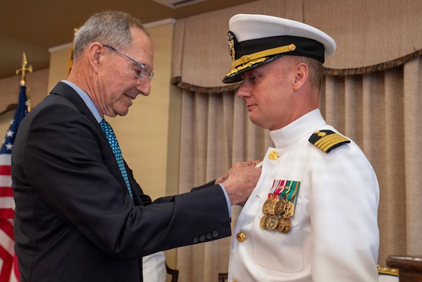 Capt. Kevin Lyle, U.S. Navy Medical Service Corps, has his command pin pinned by Rear Adm. (retired) Michael Mittelman, U.S. Navy Medical Service Corps, during the Change of Command ceremony aboard Naval Station Newport, R.I., June 10, 2026. Prior to assuming command of NMRTC New England, Capt. Lyle served as the Executive Officer and Deputy Director of Navy Medicine Readiness and Training Command and Naval Health Clinic Charleston, South Carolina (U.S. Navy photo by Mass Communication Specialist 1st Class Jacob Allison)