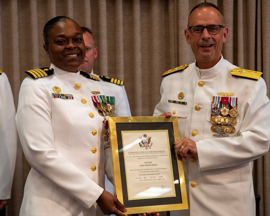 Rear Adm. Robert Hawkins, director of Defense Health Network Atlantic and commander of Naval Medical Forces Atlantic, right, presents a certificate of retirement to Capt. Rona Green during her retirement ceremony aboard Naval Station Newport, R.I., June 10, 2026. Green served the Navy for 37 years of dedicated and honorable service. (U.S. Navy photo by Mass Communication Specialist 1st Class Jacob Allison)