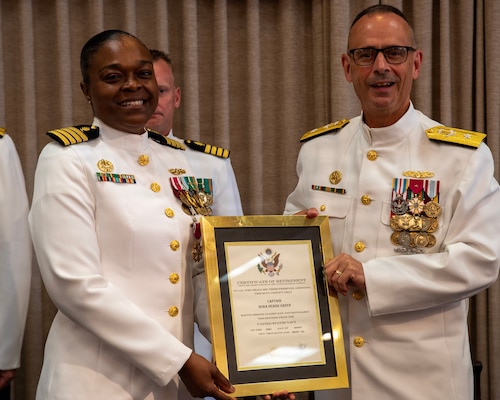 Rear Adm. Robert Hawkins, director of Defense Health Network Atlantic and commander of Naval Medical Forces Atlantic, right, presents a certificate of retirement to Capt. Rona Green during her retirement ceremony aboard Naval Station Newport, R.I., June 10, 2026. Green served the Navy for 37 years of dedicated and honorable service. (U.S. Navy photo by Mass Communication Specialist 1st Class Jacob Allison)