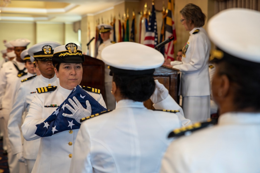 Cmdr. Amanda Jimenez-Myers, assigned to Navy Medicine Readiness and Training Command New England, participates in the flag passing ceremony during the retirement ceremony of Capt. Rona Green, aboard Naval Station Newport, R.I., June 10, 2026. Green served the Navy for 37 years of dedicated and honorable service. (U.S. Navy photo by Mass Communication Specialist 1st Class Jacob Allison)