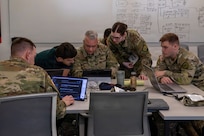 U.S. Army National Guard Soldiers and a civilian cybersecurity specialist collaborate at a workstation to mitigate a simulated network breach during Exercise Cyber Tatanka 2026 in Lincoln, Nebraska, June 9, 2026.