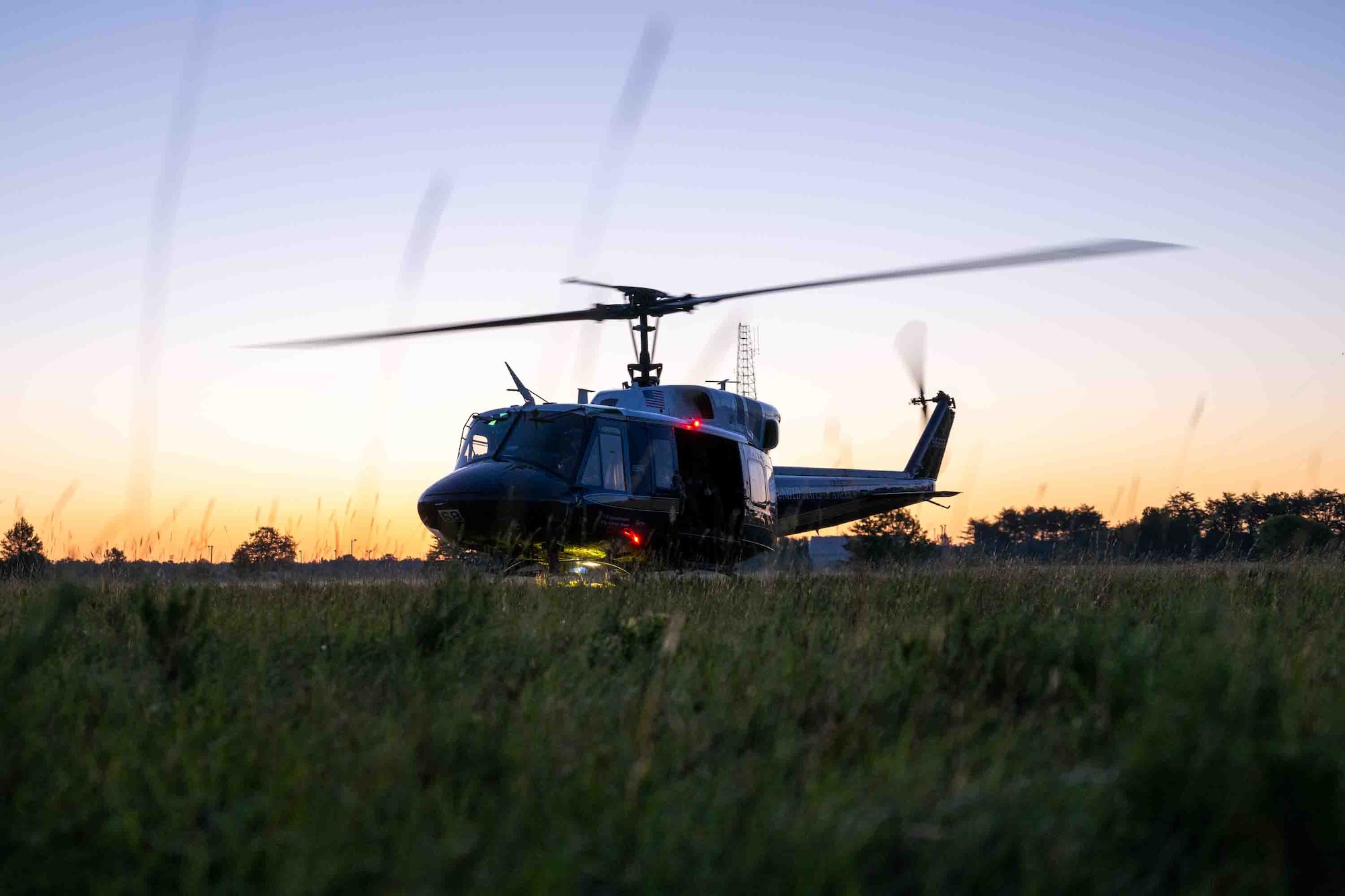 Service members fly in a helicopter.