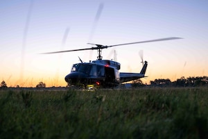 Service members fly in a helicopter.