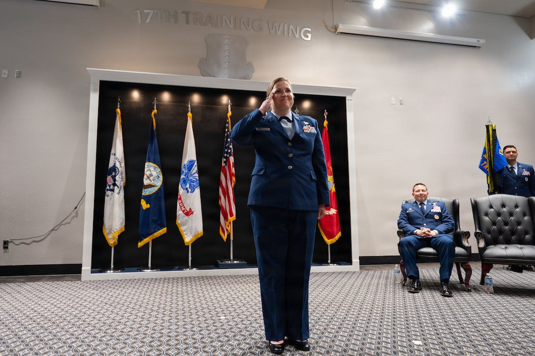 A service member salutes toward a crowd