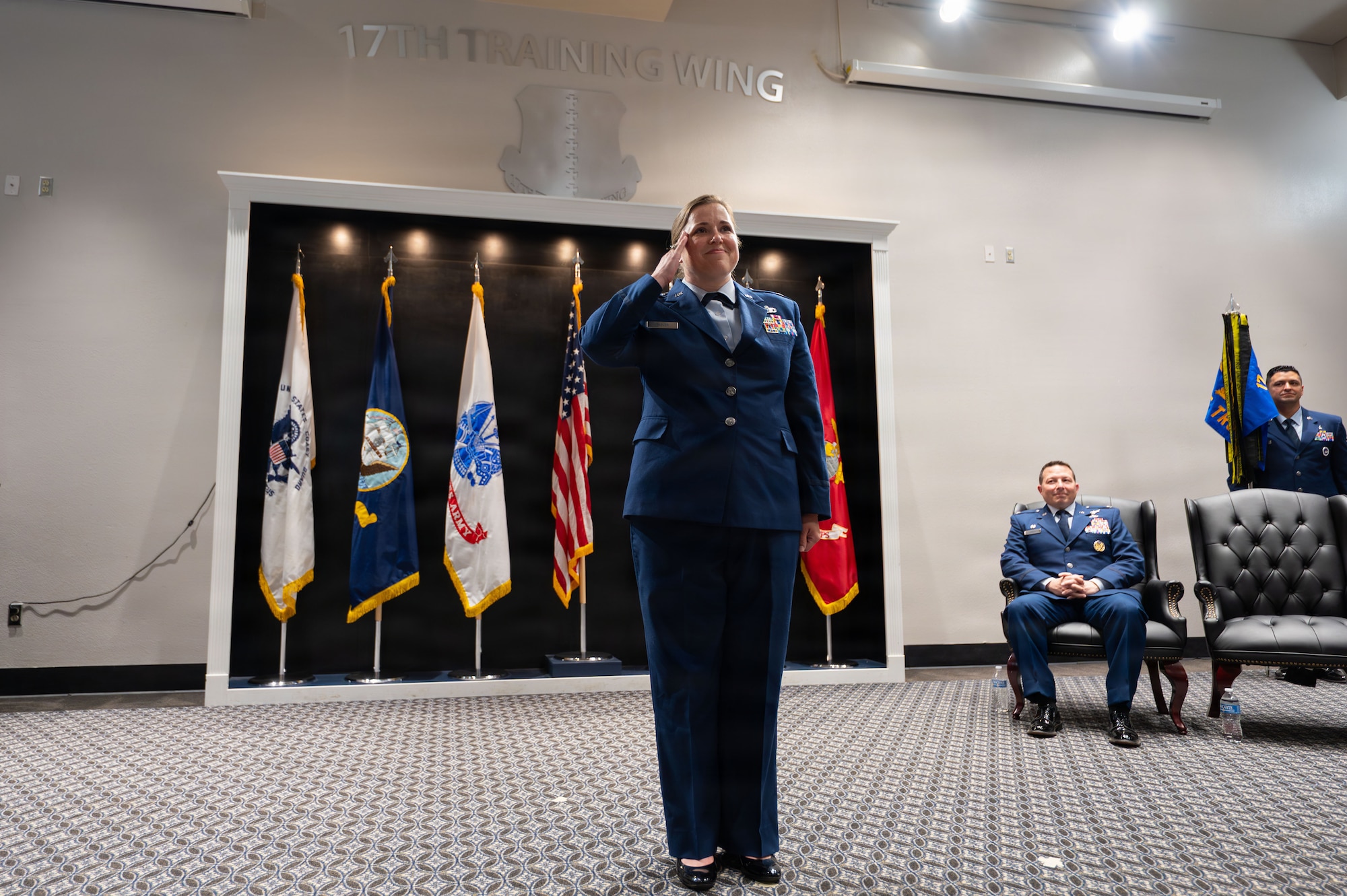 A service member salutes toward a crowd