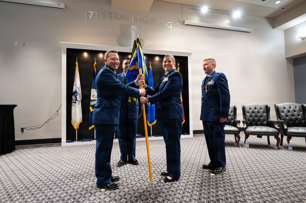 A unit guidon is exchanged between two service members
