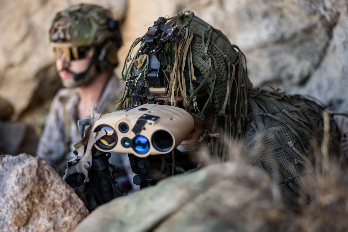 U.S. Marine Corps Sgt. Samuel Dentchevkruse, right, a native of North Carolina and a network administrator with 5th Air Naval Gunfire Liaison Company, III Marine Expeditionary Force Information Group, observes a target area through a common laser range finder-integrated capability during Resolute Hunter 26-2 at Fallon, Nevada, June 16, 2026. Resolute Hunter is a biannual joint and coalition exercise that provides 5th ANGLICO a realistic operational environment to integrate reconnaissance and surveillance operations, refine communications tactics, techniques, and procedures, and strengthen joint force targeting and kill web integration in support of future deployments and multi-domain operations. (U.S. Marine Corps photo by Sgt. Raymond Tong)