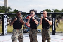 U.S. Marine Sgts. Arkel Brown, Ryan McCartney, and Gunnery Sgt. Jack Pavao pose for photos inside the octagon during the UFC Freedom 250 Fan Fest at the Ellipse in Washington, D.C., June 14, 2026. McCartney represented the Department of War during a combatives showcase highlighting military readiness, discipline, and hand-to-hand combat skills as part of the Freedom 250 celebration. (U.S. Army photo by Sgt. 1st Class Brittany Primavera)