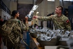U.S. Army 2nd Lt. Jacob Quanbeck, medical student in the Basic Officer Leadership Course, right, helps issue helmets inside the 502d Logistics Readiness Squadrons Central Issue Facility (CIF) on Joint Base San Antonio-Fort Sam Houston, June 12, 2026. This equipment provides service members with functional uniforms and life-saving gear tailored to specific tactical and climatic demands. (U.S. Air Force photo by Melissa Hydrick)