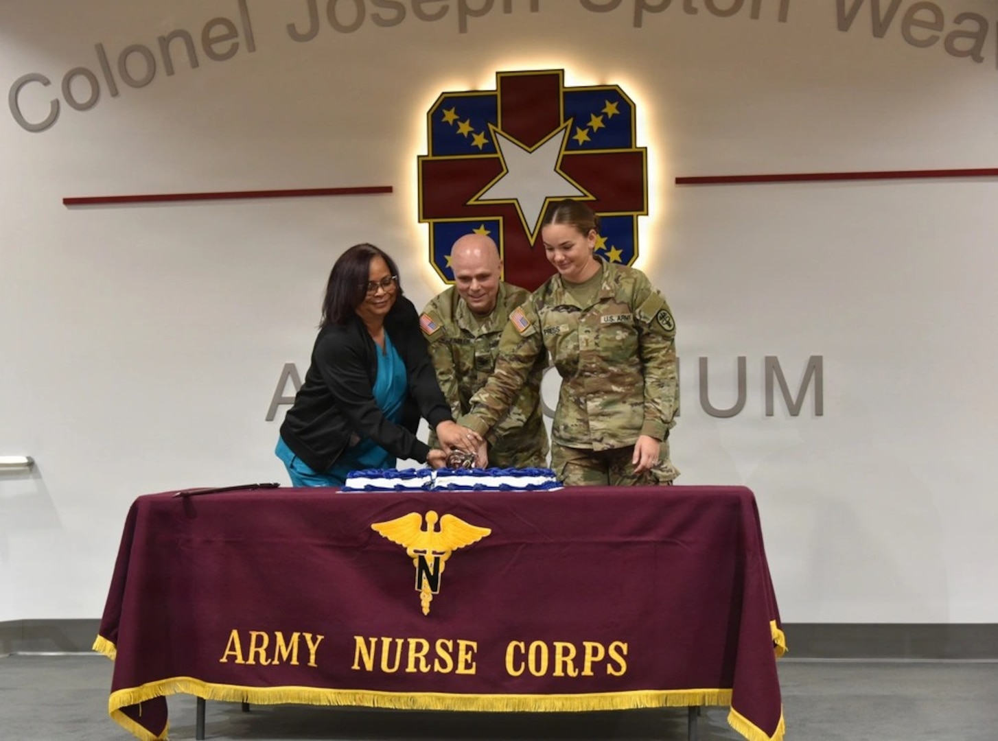 Womack Army Medical Center kicks off Nurses Week with opening ceremony. (From left) Suzette Lambert, Col. Donald Kimbler, WAMC Chief Nursing Officer and 2nd Lt. Jocelyn Press, participate in traditional cake cutting ceremony, May 4, 2026, Fort Bragg, North Carolina. (Photo by Keisha Frith, Womack Army Medical Center Public Affairs Office)