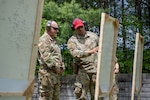 Photo of U.S. Army Brig. Gen. Matthew Brown, left, the director of the joint staff, chief of staff, Army, Vermont National Guard, checking his shot placement with U.S. Air Force Tech. Sgt. Trey Lytle, right, a combat arms instructor assigned to the 158th Security Forces Squadron, while qualifying on his weapon at the Ethan Allen Firing Range in Jericho, Vermont.