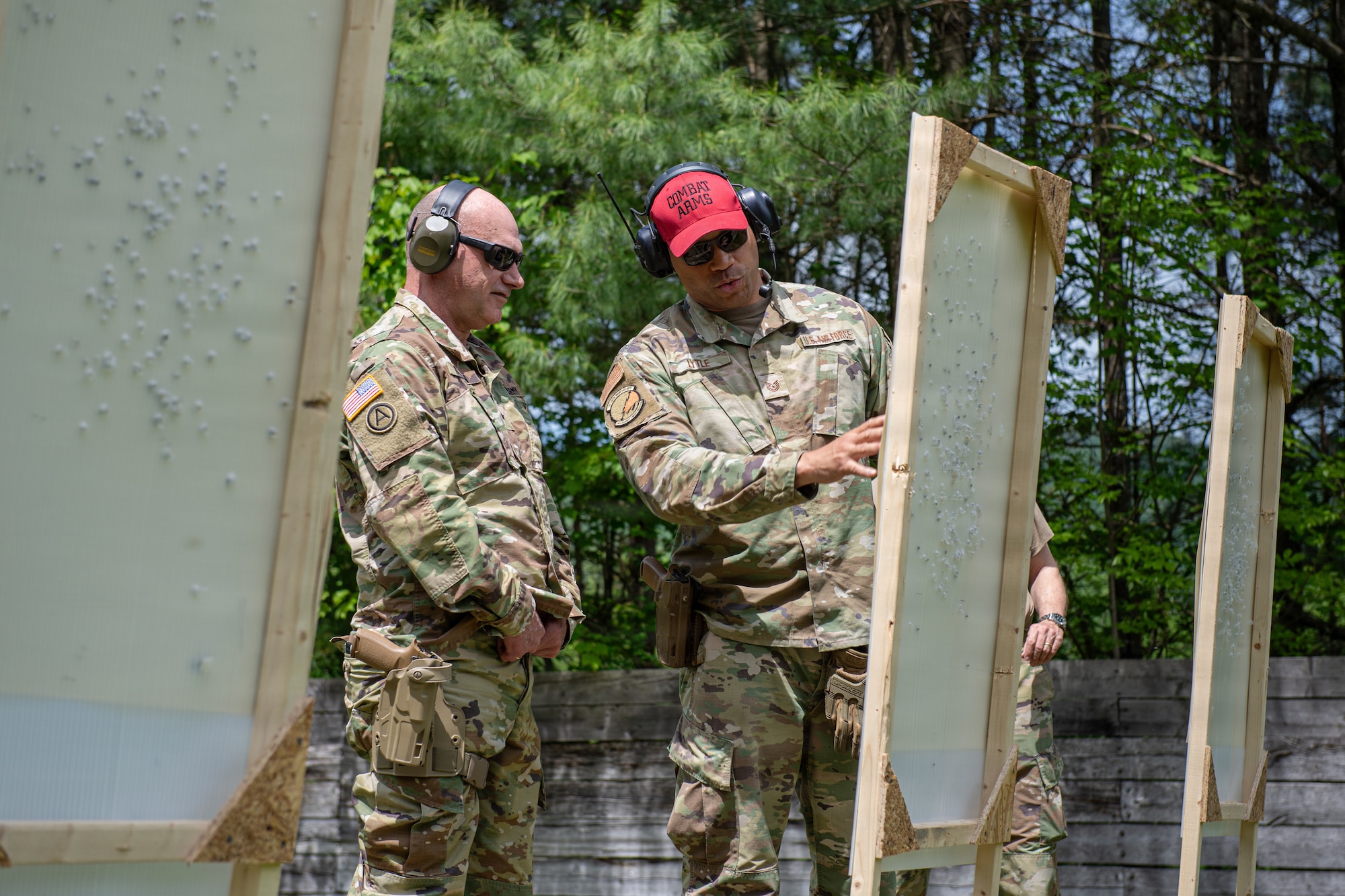 Photo of U.S. Army Brig. Gen. Matthew Brown, left, the director of the joint staff, chief of staff, Army, Vermont National Guard, checking his shot placement with U.S. Air Force Tech. Sgt. Trey Lytle, right, a combat arms instructor assigned to the 158th Security Forces Squadron, while qualifying on his weapon at the Ethan Allen Firing Range in Jericho, Vermont.