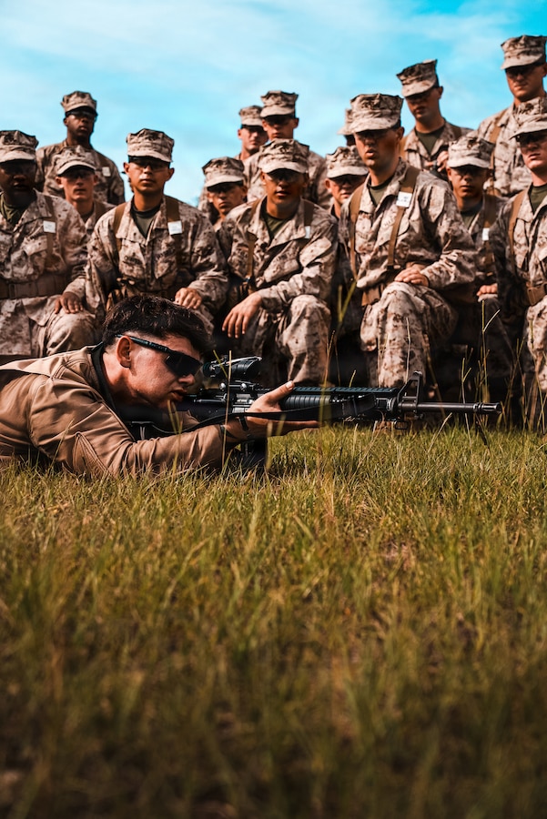 U.S. Marine Corps Sgt. Jackson Smith, a primary marksmanship instructor with Range Company, Weapons and Field Training Battalion, instructs recruits with Alpha Company, 1st Recruit Training Battalion during Grass Week on Marine Corps Recruit Depot Parris Island, S.C., June 9, 2026. During Grass Week, recruits learn and test on rifle operation and usage in preparation for Table One Qualification the following week. (U.S. Marine Corps photo by Cpl. Jordy Morales)