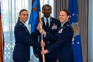 U.S. Air Force Col. Angelique Nelson, left, 11th Mission Support Group commander, presents Lt. Col. Krystal McGuiness, 11th Logistics Readiness Squadron incoming commander, with the unit guidon during the 11th LRS change of command ceremony at Joint Base Anacostia-Bolling, Washington, D.C., June 16, 2026. McGuiness previously served as the deputy chief, Force Projection Analysis Division for the Office of the Secretary of the Air Force, Studies and Analysis. (U.S. Air Force photo by Airman 1st Class Brandon Thomas)