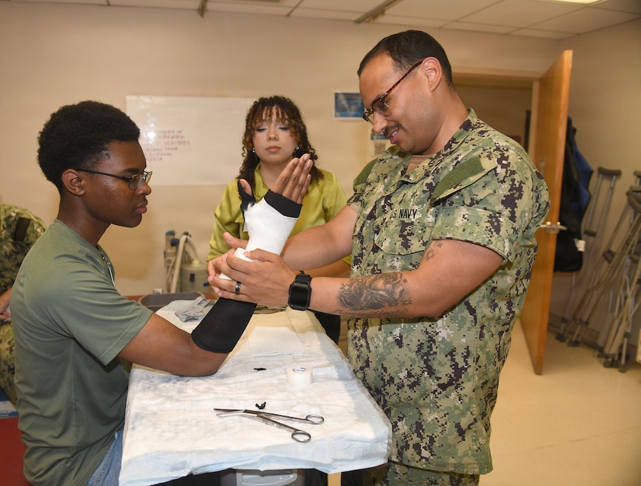 260610-N-JB216-2385 Jacksonville, Fla. (June 12, 2026) The annual Science, Service, Medicine, and Mentoring (S2M2) program at Naval Hospital Jacksonville concluded another impactful week!  From June 8-12, students from Darnell-Cookman School of the Medical Arts explored a variety of medical departments, gaining firsthand experience through hands-on activities, demonstrations, and mentorship from healthcare professionals. Students engaged in orthopedic splinting and casting stations, gaining practical experience in how injuries are stabilized and supported through proper application techniques. (U.S. Navy photo by Kie Savage).