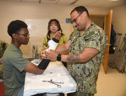 260610-N-JB216-2385 Jacksonville, Fla. (June 12, 2026) The annual Science, Service, Medicine, and Mentoring (S2M2) program at Naval Hospital Jacksonville concluded another impactful week!  From June 8-12, students from Darnell-Cookman School of the Medical Arts explored a variety of medical departments, gaining firsthand experience through hands-on activities, demonstrations, and mentorship from healthcare professionals. Students engaged in orthopedic splinting and casting stations, gaining practical experience in how injuries are stabilized and supported through proper application techniques. (U.S. Navy photo by Kie Savage).