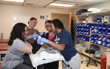 260610-N-JB216-7879 Jacksonville, Fla. (June 12, 2026) The annual Science, Service, Medicine, and Mentoring (S2M2) program at Naval Hospital Jacksonville concluded another impactful week!  From June 8-12, students from Darnell-Cookman School of the Medical Arts explored a variety of medical departments, gaining firsthand experience through hands-on activities, demonstrations, and mentorship from healthcare professionals. Students engaged in orthopedic splinting and casting stations, gaining practical experience in how injuries are stabilized and supported through proper application techniques. (U.S. Navy photo by Kie Savage).