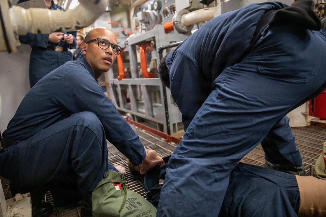 Hospital Corpsman 3rd Class Steward Cotui Mercedes checks vitals on a mock casualty during a casualty clearing drill in an engine room of the guided missile destroyer USS Donald Cook (DDG 75), Feb. 17, 2022. Cotui Mercedes now assigned to Naval Branch Health Clinic Mayport was recently named one of five hospital corpsmen in the Navy to be awarded the Danyelle Luckey Sacred Trust Award. (U.S. Navy photo by Mass Communication Specialist Seaman Nicholas M. Skyles)