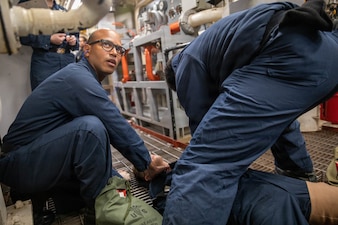 Hospital Corpsman 3rd Class Steward Cotui Mercedes checks vitals on a mock casualty during a casualty clearing drill in an engine room of the guided missile destroyer USS Donald Cook (DDG 75), Feb. 17, 2022. Cotui Mercedes now assigned to Naval Branch Health Clinic Mayport was recently named one of five hospital corpsmen in the Navy to be awarded the Danyelle Luckey Sacred Trust Award. (U.S. Navy photo by Mass Communication Specialist Seaman Nicholas M. Skyles)
