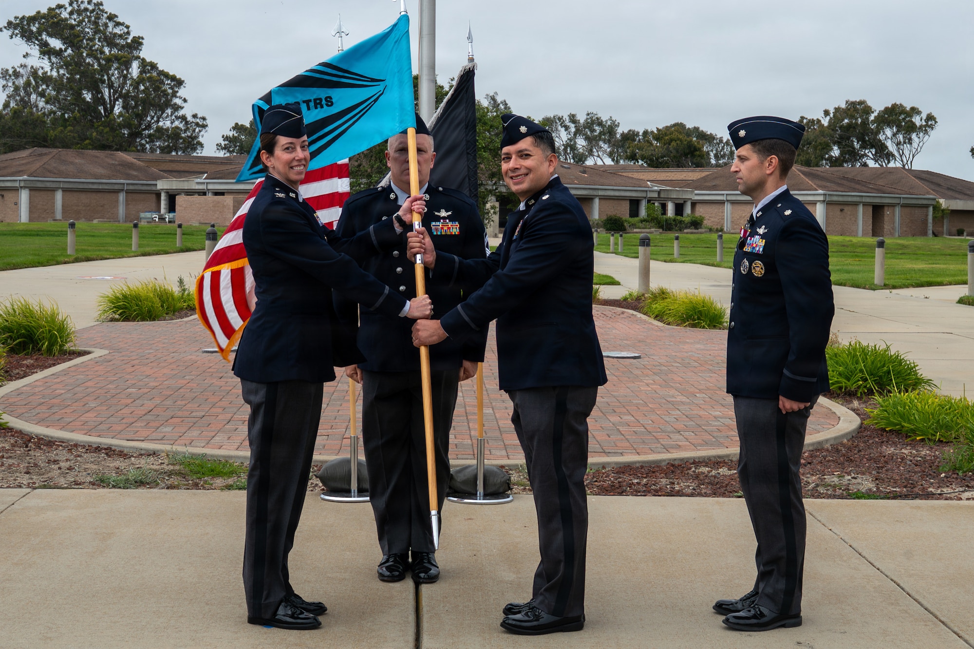 Two people hold a flag and stand