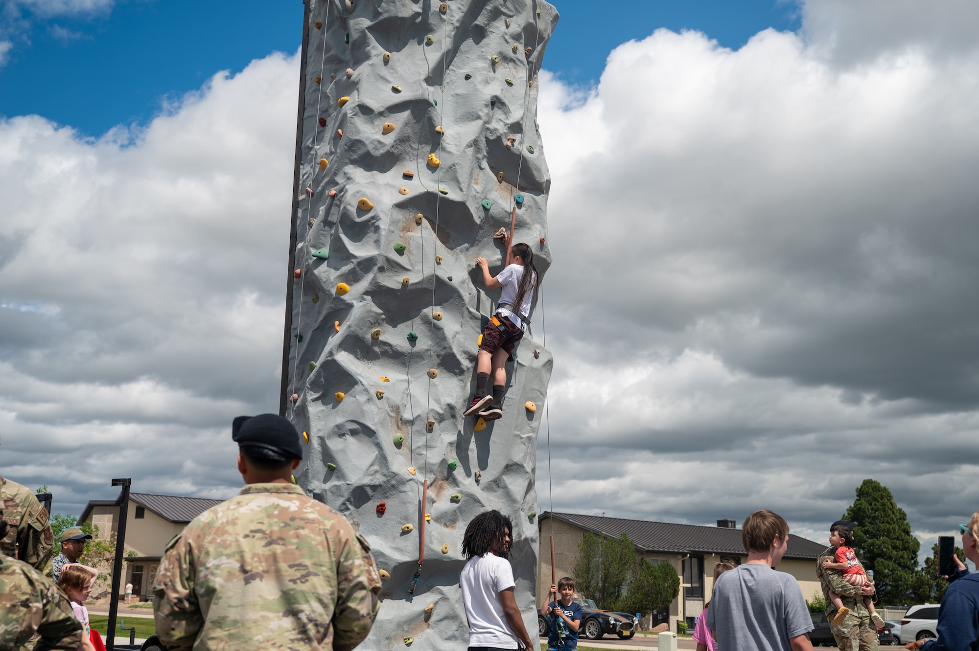 A young boy climbs a rock wall.