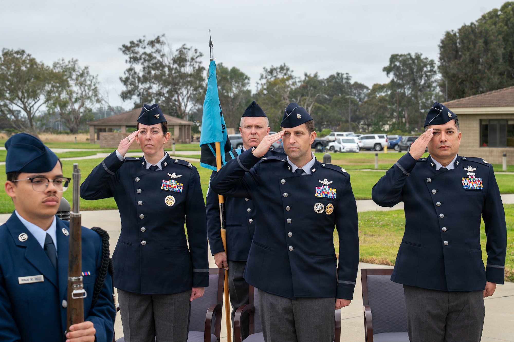 Five people stand and honor the presentation of colors