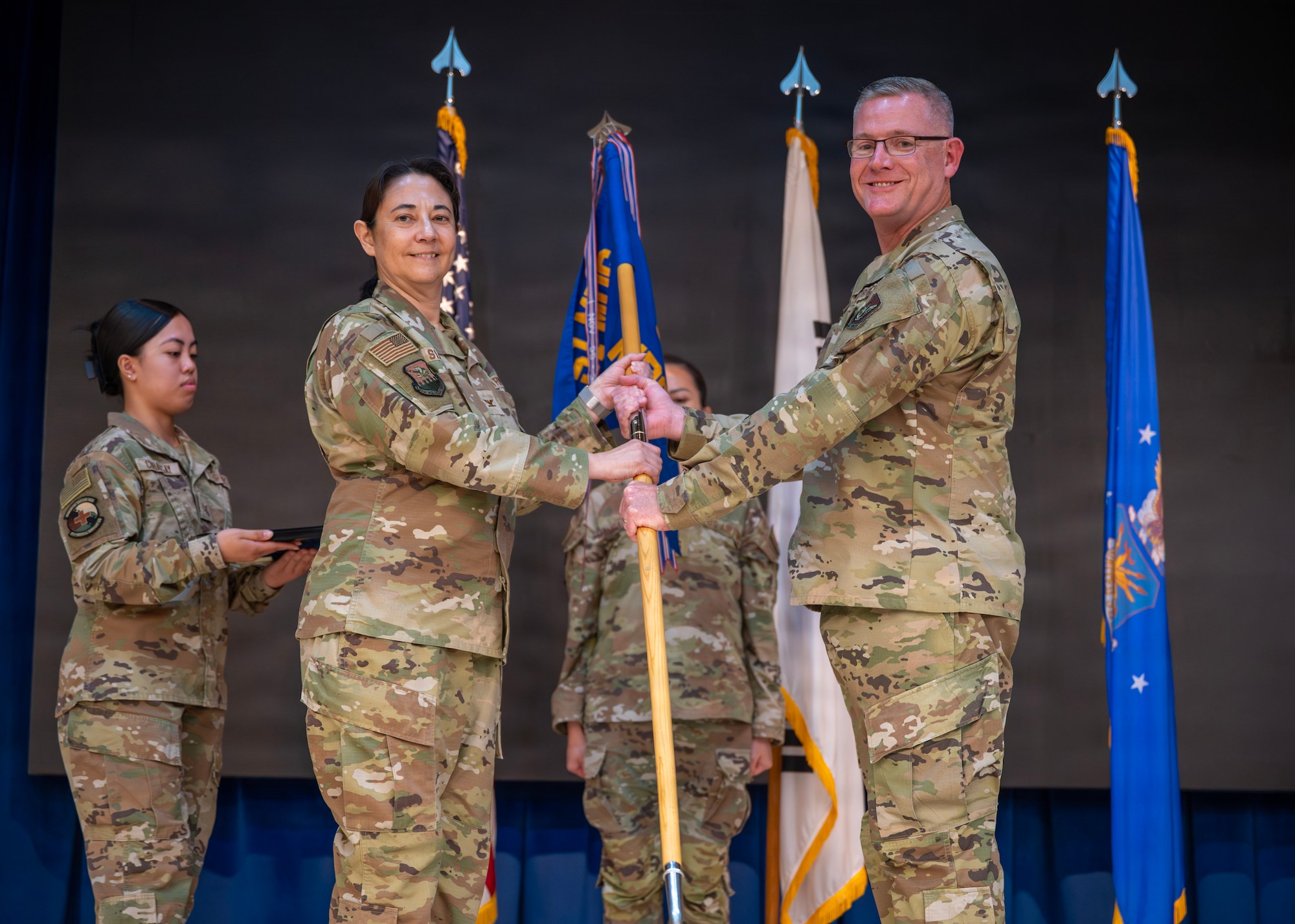 U.S. Air Force Lt. Col. Jacob Williams, right, incoming commander of the 51st Medical Support Squadron, accepts command of the 51st MDSS from Col. Amanda Siangco, 51st Medical Group commander, during a change of command ceremony at Osan Air Base, Republic of Korea, June 22, 2026. A change of command ceremony formally transfers authority and responsibility from one commander to another, ensuring continuity of leadership and mission readiness within the Wing. (U.S. Air Force photo by Staff Sgt. Sarah Williams)
