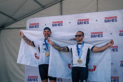Retired U.S. Army Sgt. 1st. Class Greg Quarles, left, and Staff Sgt. Xavier Rodgers, right, pose for a photo after receiving gold medals for the upright tandem cycling event at the 2026 Warrior Games in San Antonio, Texas, June 14, 2026.