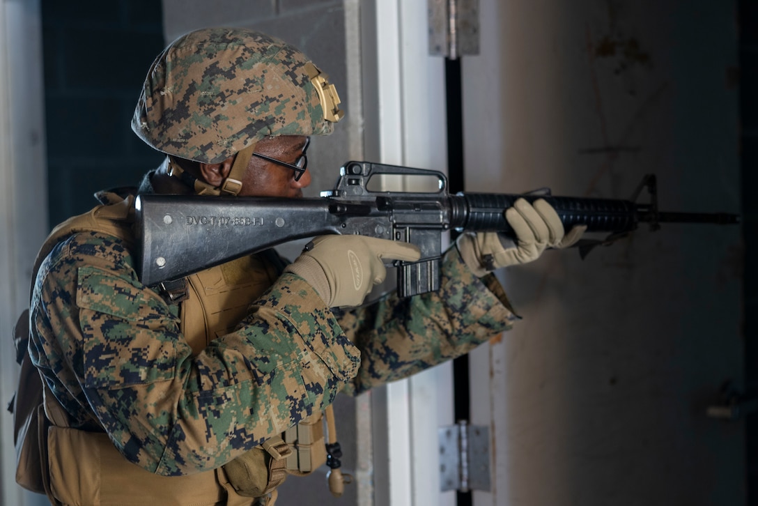 U.S. Marine Corps Pfc. Malachi Owusu, a graphic design specialist with 2nd Marine Division Communication Strategy and Operations, provides security during a simulated raid as part of  the II Marine Expeditionary Force COMMSTRAT Exercise 2025 at Marine Corps Base Camp Lejeune, North Carolina, May 22, 2025. II MEF COMMSTRAT held the exercise to validate established standards, sustain productivity, and enhance cross-functional collaboration among COMMSTRAT units in the II MEF area of operations. (U.S. Marine Corps photo by Lance Cpl. John Allen)