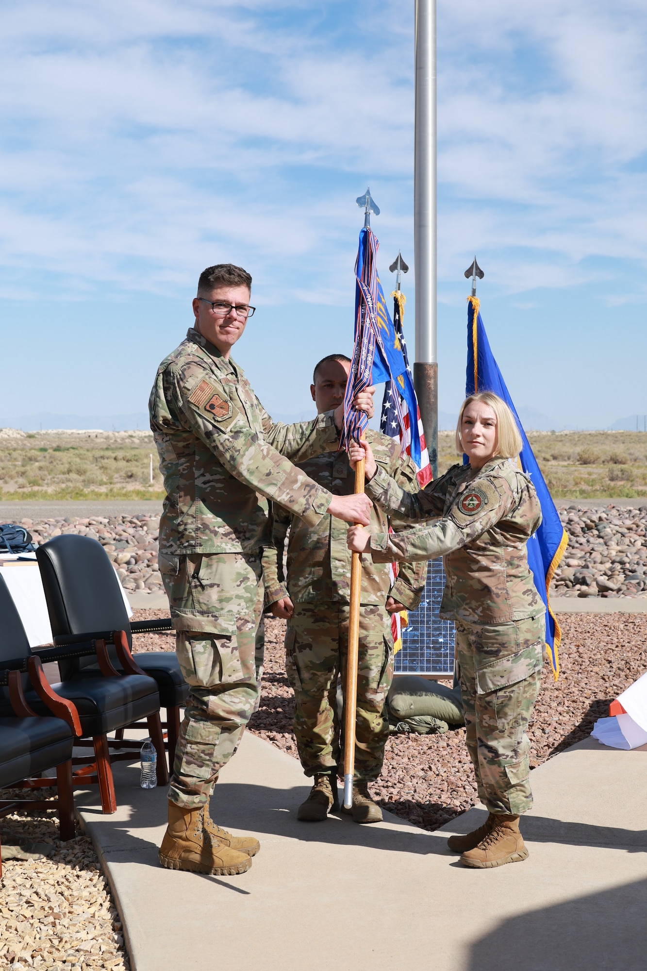 Lt. Col. Michelle Willett, right, takes the guidon from 704th Test Group Commander Col. Wayne Dirkes, left, to assume the role of 846th Test Squadron commander during a June 11, 2026, Change of Leadership ceremony at Holloman Air Force Base, N.M. The 846th TS is a unit of Arnold Engineering Development Complex. (U.S. Air Force photo by Ashleigh Ahrens)