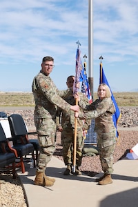 Lt. Col. Michelle Willett, right, takes the guidon from 704th Test Group Commander Col. Wayne Dirkes, left, to assume the role of 846th Test Squadron commander during a June 11, 2026, Change of Leadership ceremony at Holloman Air Force Base, N.M. The 846th TS is a unit of Arnold Engineering Development Complex. (U.S. Air Force photo by Ashleigh Ahrens)