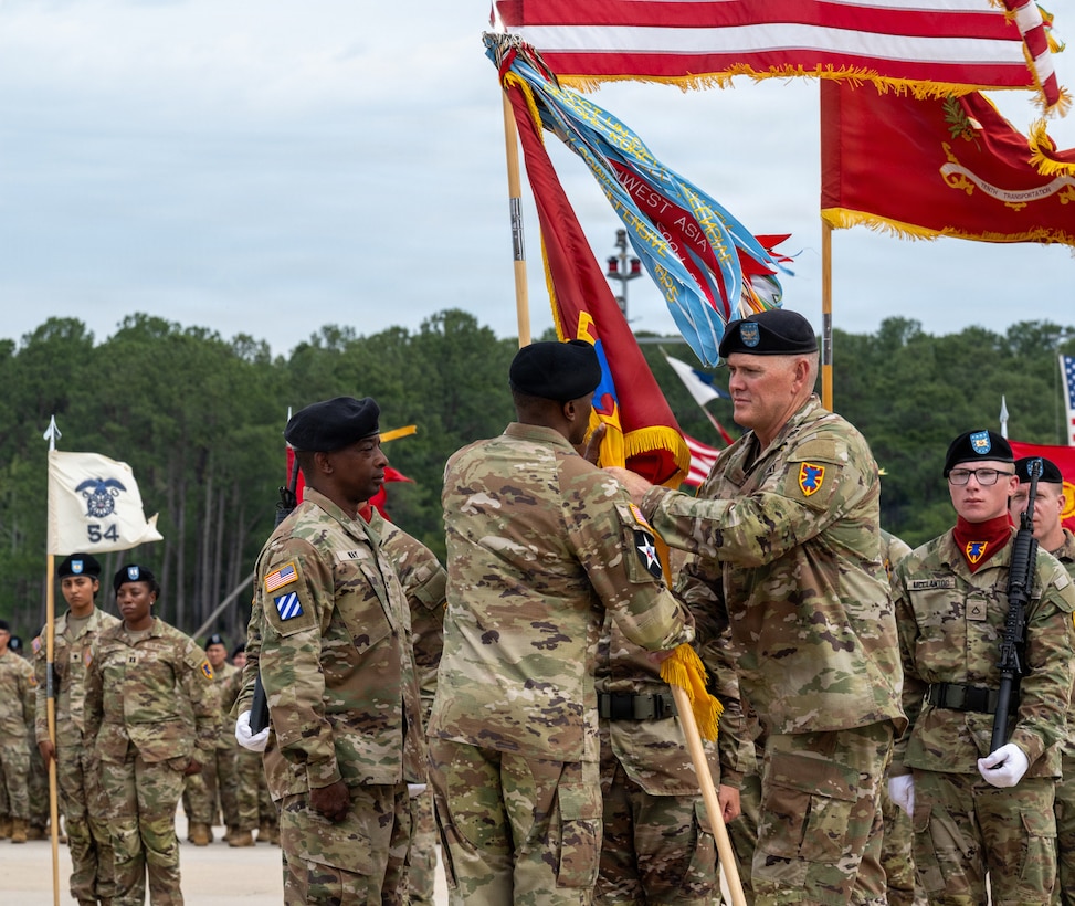 A Soldier passes a flag to a General.