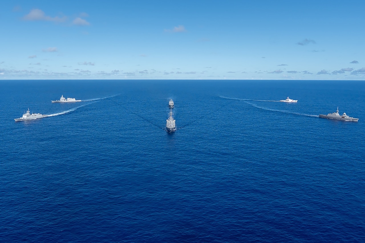 Six ships create a fan shape in blue water.