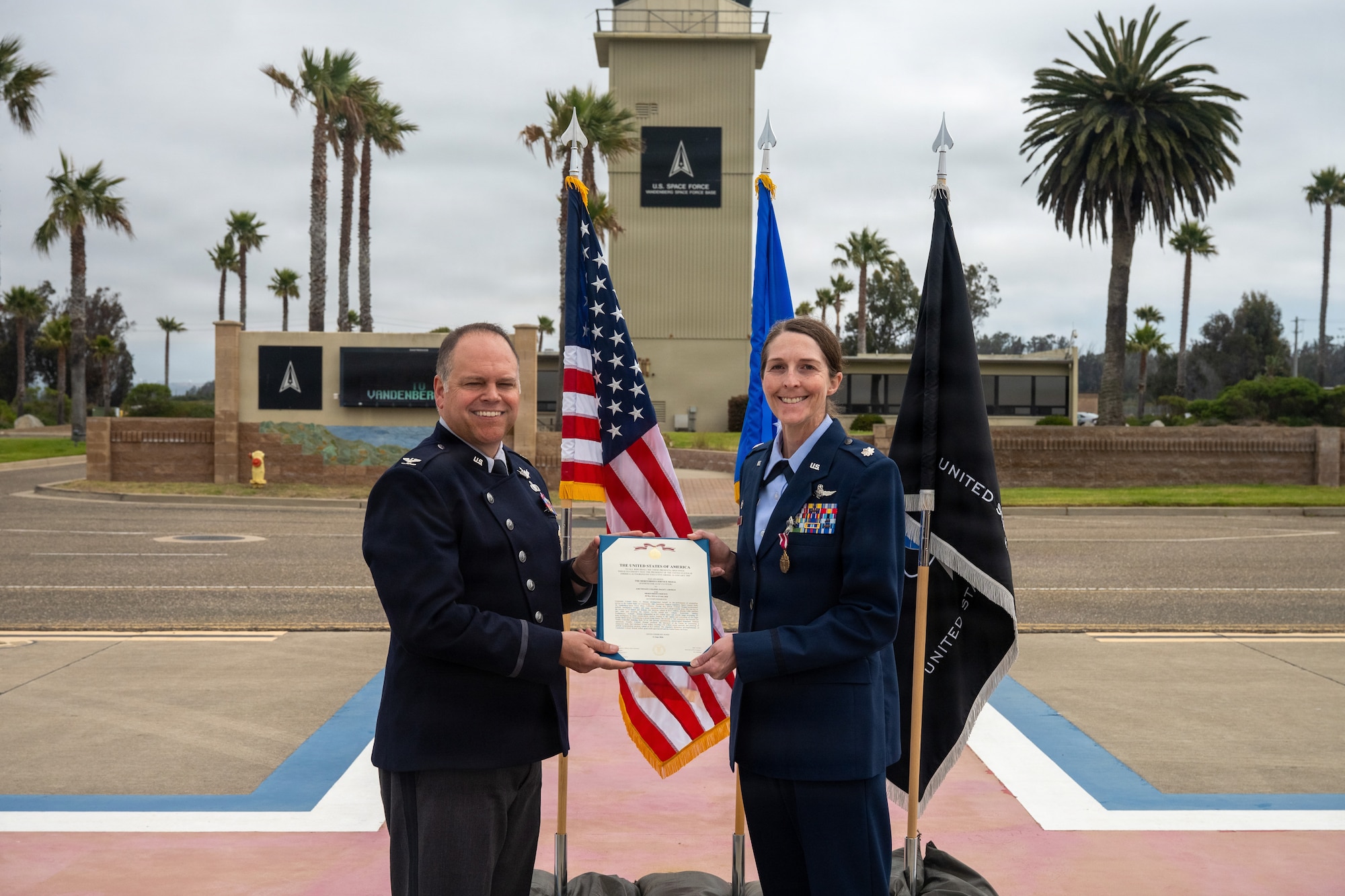 Col. James T. Horne III presents the meritorious service medal award to Lt. Col. Haley Homan on the airfield.