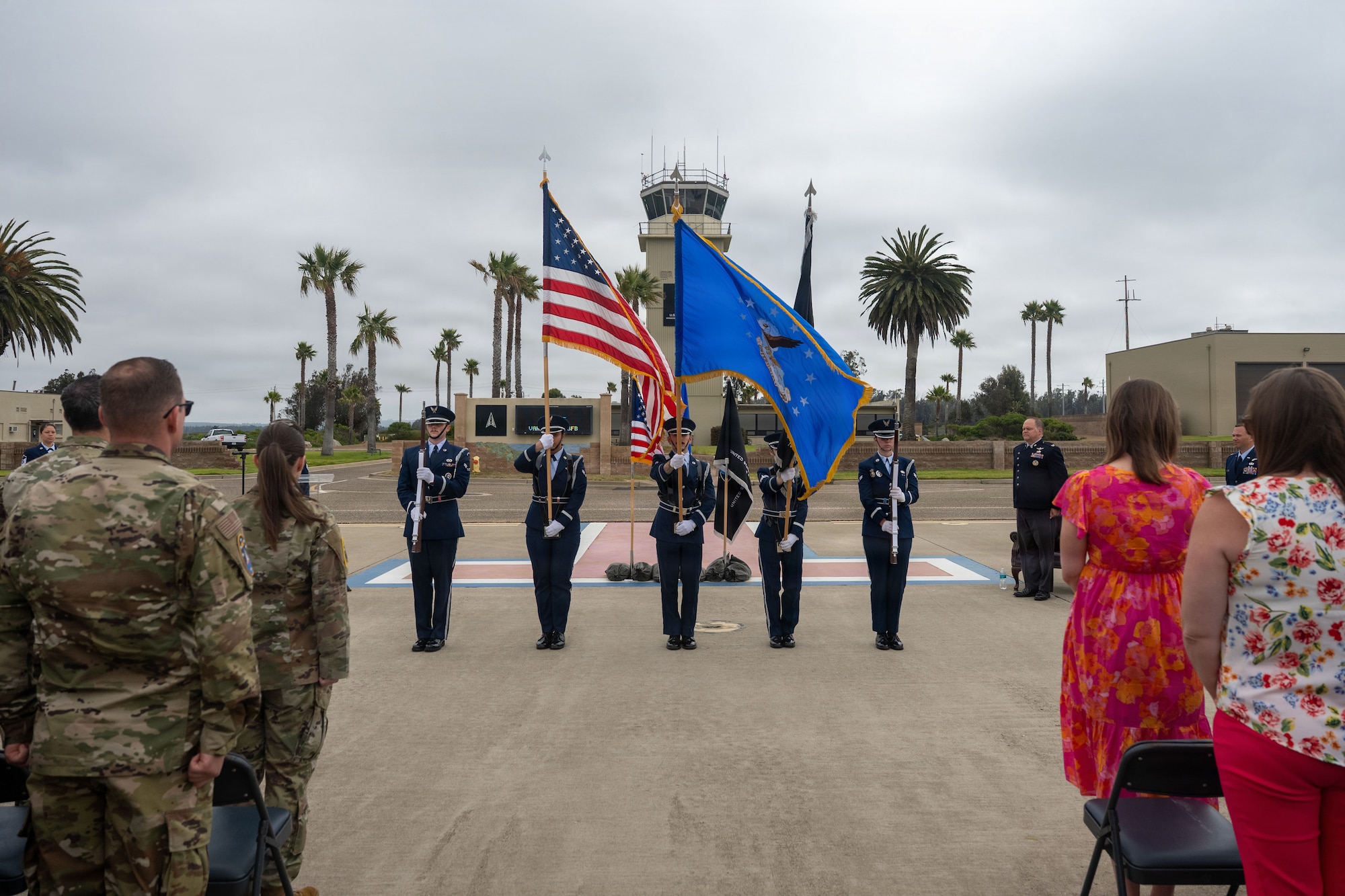 The honor guard present the colors on the airfield during the change of command as everyone stands for the national anthem.