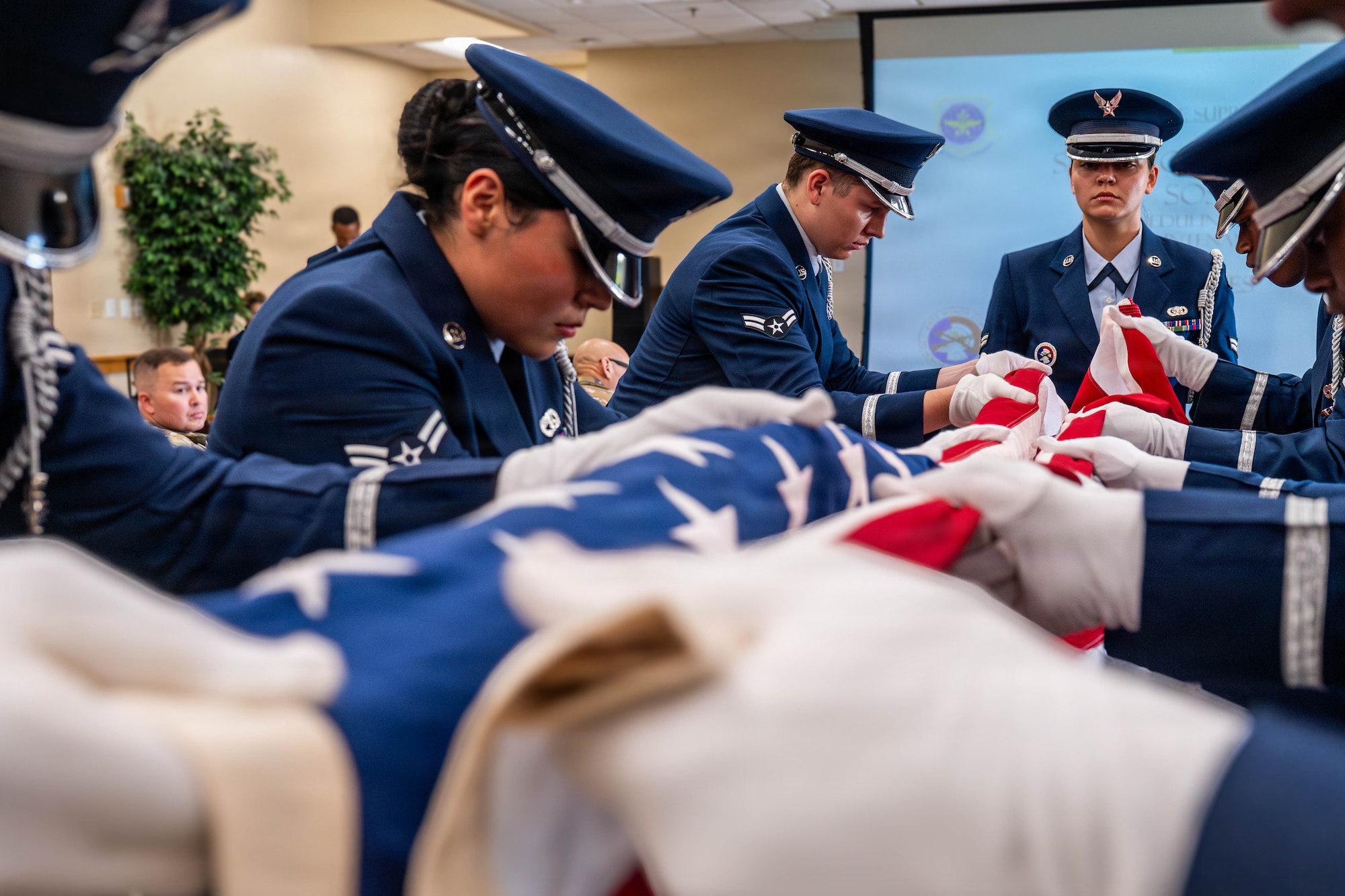 A photo of honor guard members demonstrating a Pallbearer Ritual inside of a building.
