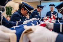 A photo of honor guard members demonstrating a Pallbearer Ritual inside of a building.
