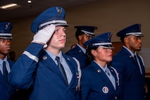 Honor Guard members salute and stand at attention during the national anthem.
