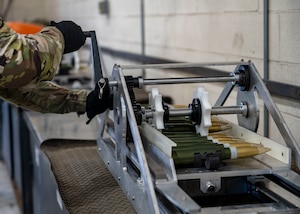 A munitions specialist assigned to the 1st Special Operations Wing operates a 30 mm ammunition linking machine