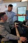 photo of two men looking at computer screens