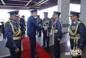Four officers in formal attire shake hands.