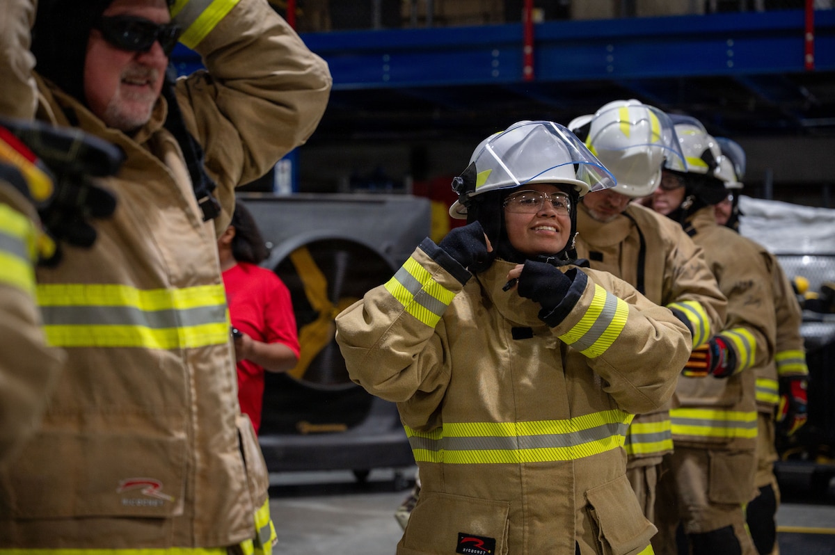 People secure fire helmets to their heads