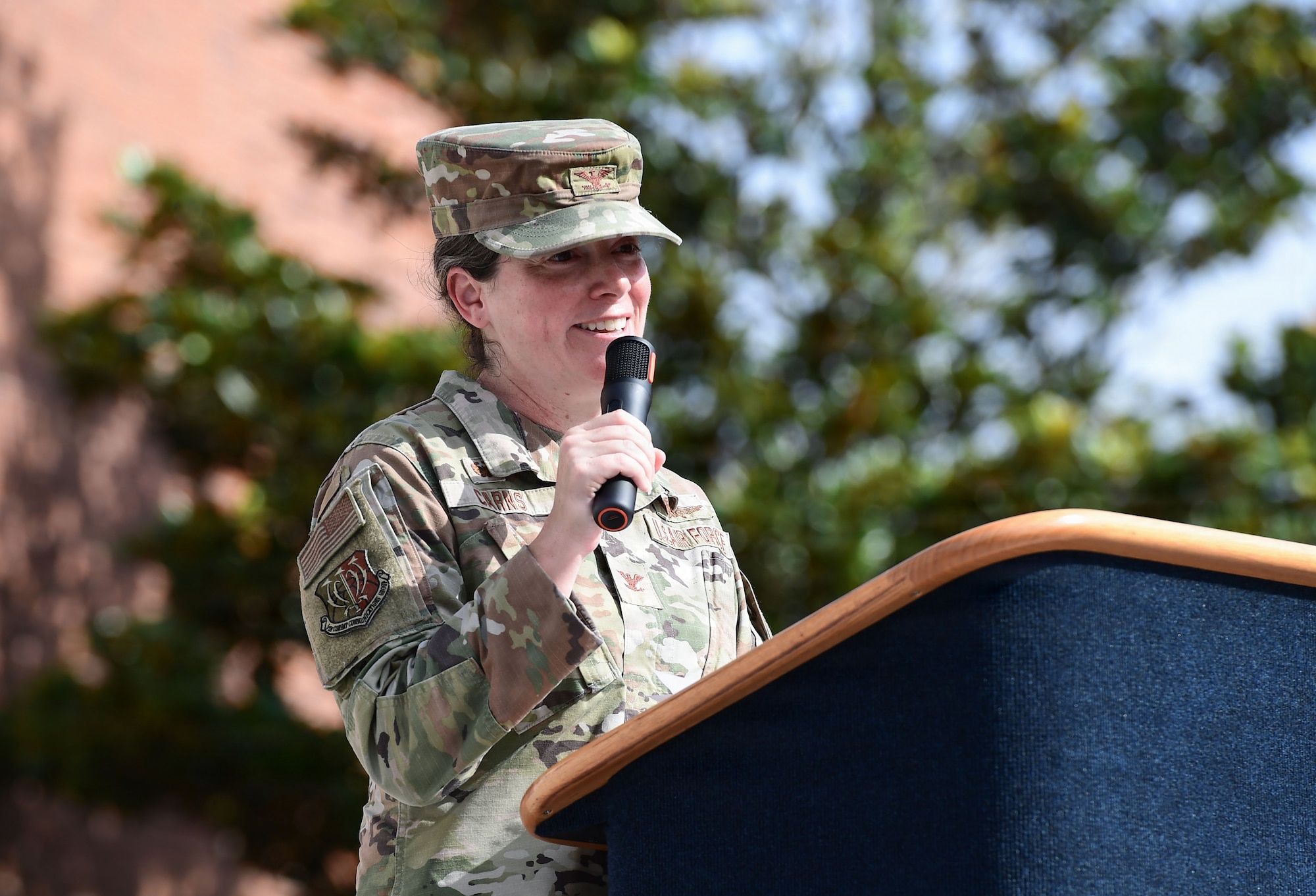 A woman in military uniform speaks from a podium.