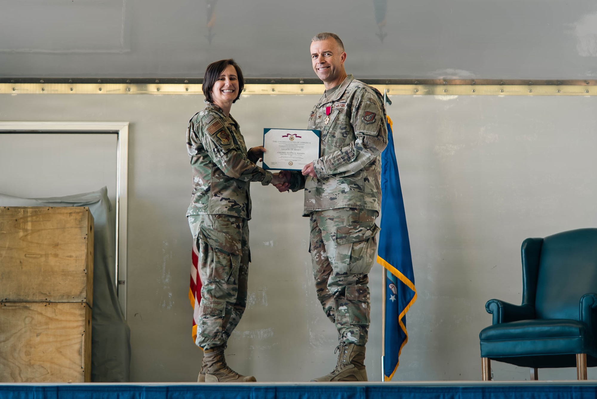 U.S. Air Force Col. Lisa Mabbutt, Joint Base Elmendorf-Richardson and 673d Air Base Wing commander, left, presents a decoration of service to Col. Dustin Hansen, outgoing 673d Mission Support Group commander, during the 673d MSG change-of-command ceremony on JBER, Alaska, June 18, 2026. The 673d MSG is composed of five squadrons – the 773d Force Support Squadron, the 673d Communications Squadron, the 673d Security Forces Squadron, the 673d Contracting Squadron and the 673d Force Support Squadron – providing support to the 673d Air Base Wing and 55 associate and tenant units assigned to JBER. (U.S. Air Force photo by Airman 1st Class Keola Vischi)